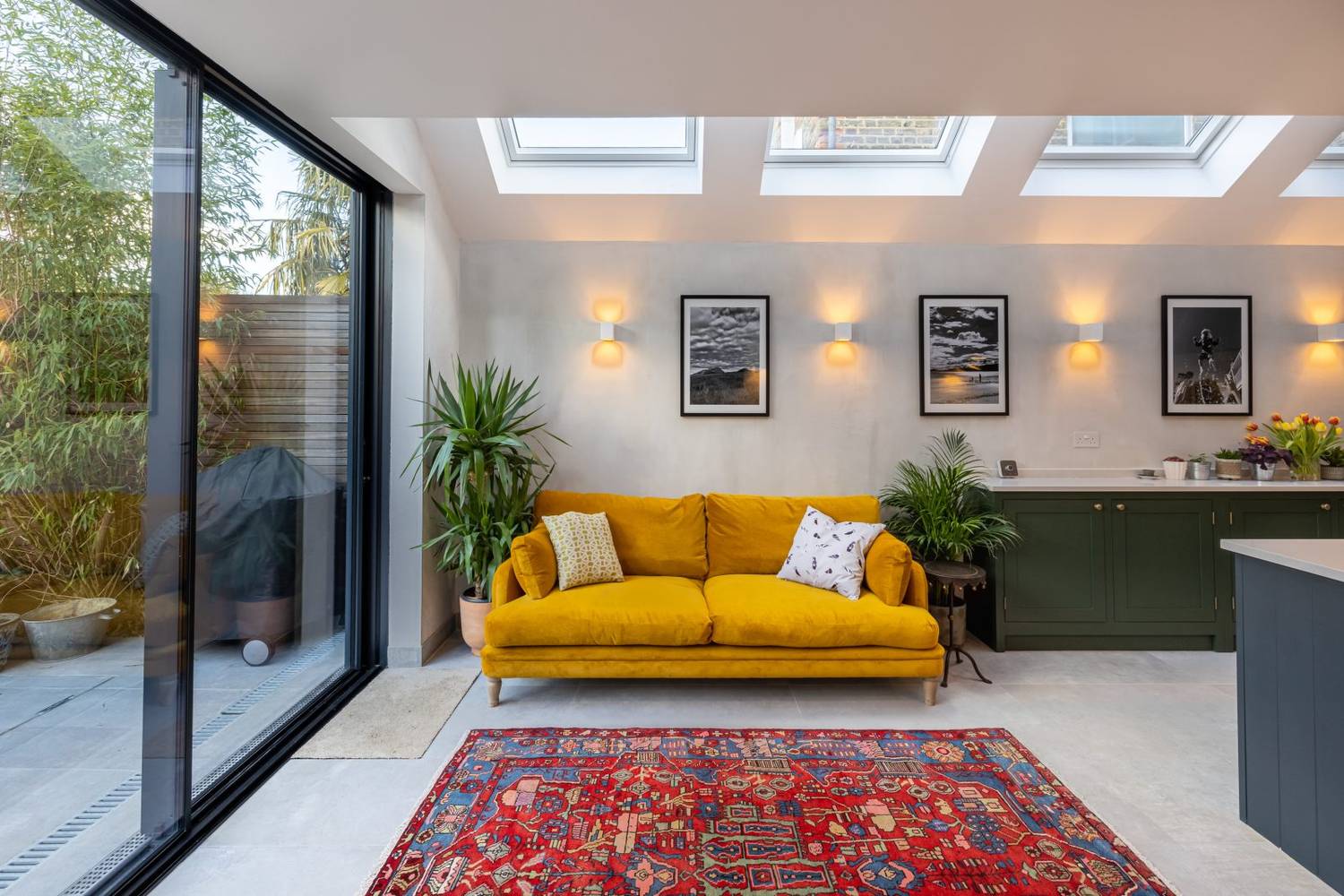 Living area under a mono-pitch lean-to roof with roof windows and a sliding door to the garden, a Build Team extension in London