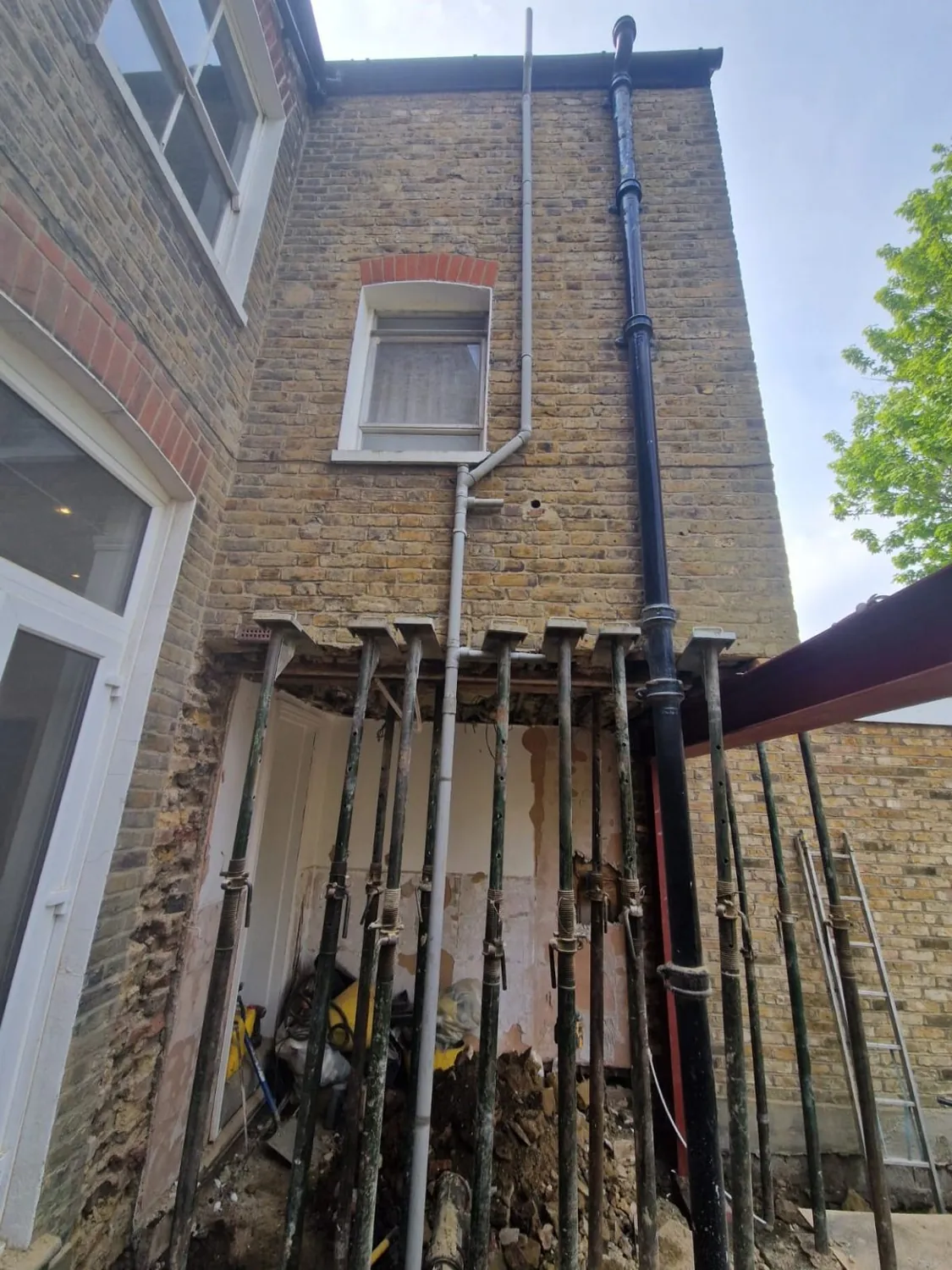 Rear wall of a London house temporarily supported on acrow props during extension structural work, a Build Team project