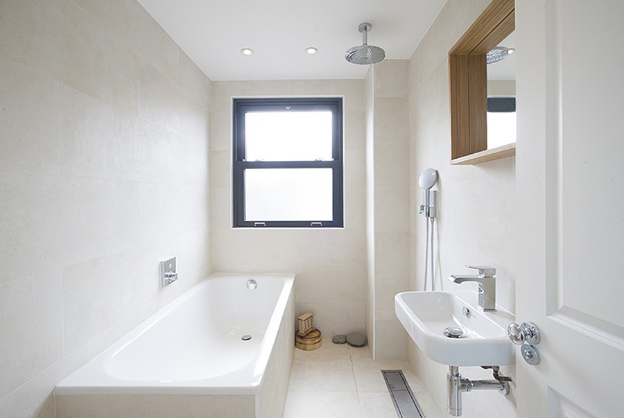 Compact bathroom with a bath, rainfall shower and small wall-hung basin, Oswyth Road