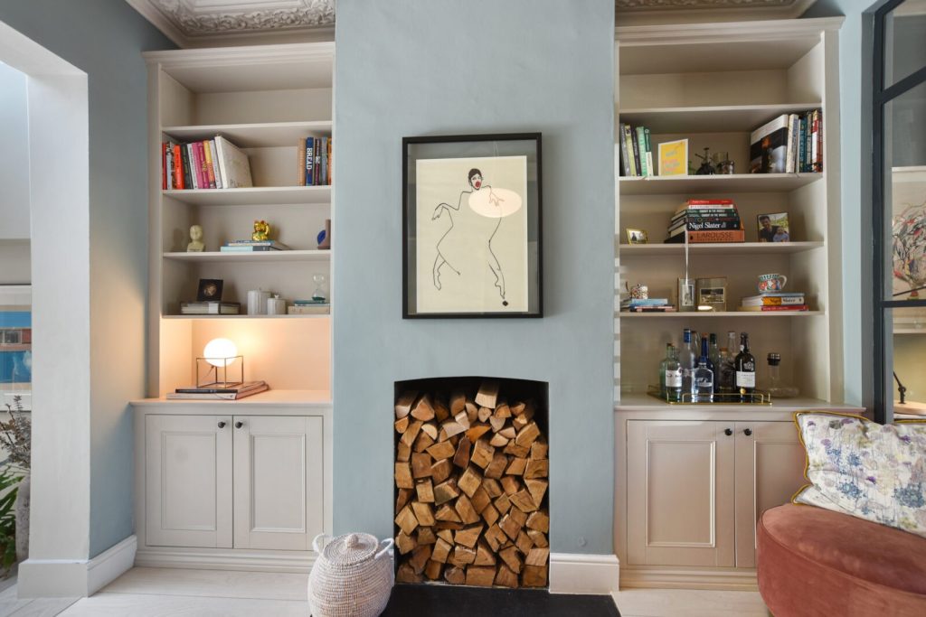 Made-to-measure shelving and cupboards fitted in the alcoves beside a chimney breast