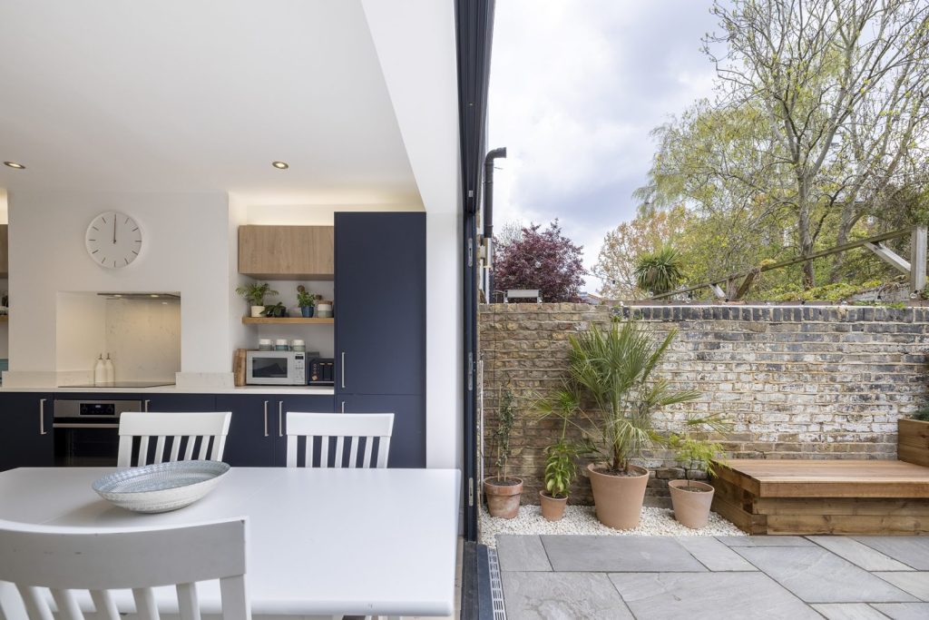 Large sliding glass patio doors opening from an extension to the garden