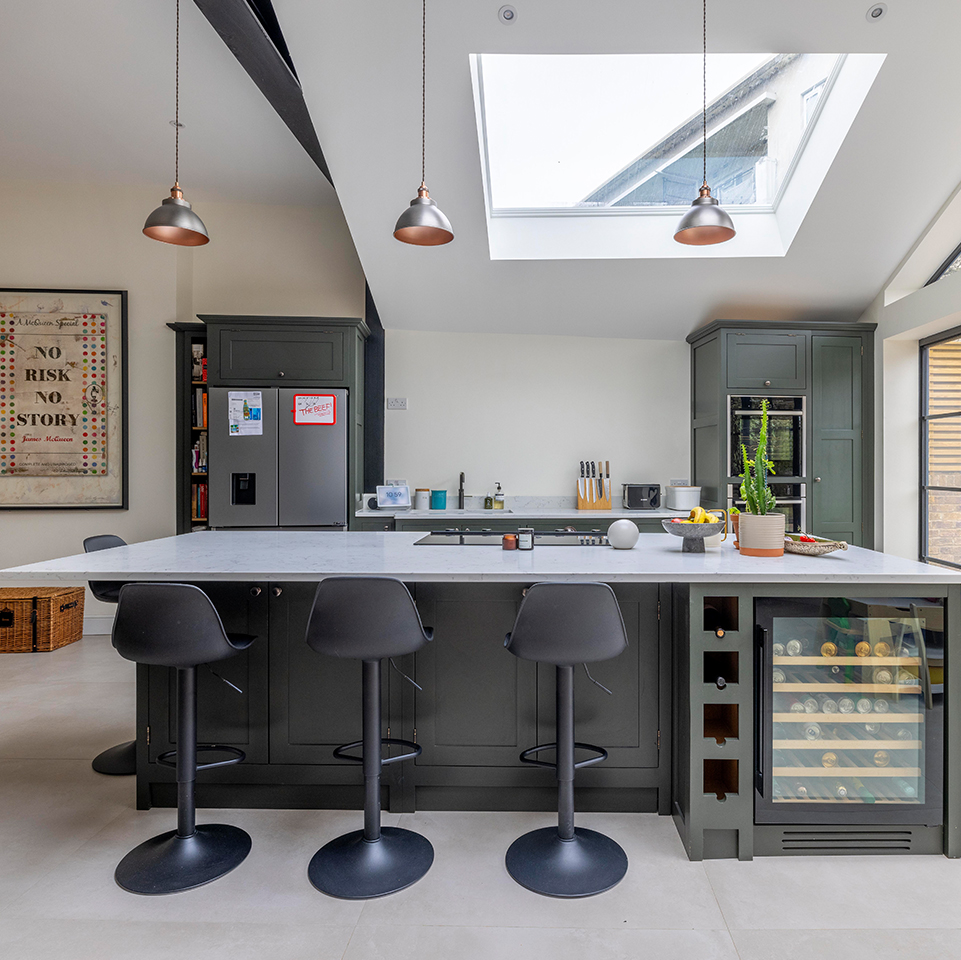 Interior showing exposed steel beams, island seating and skylights along the vaulted ceiling